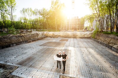 Architect and project manager standing on project site.