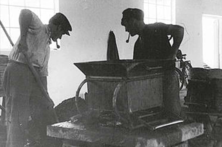 Black and white photo of two men working on a chimney